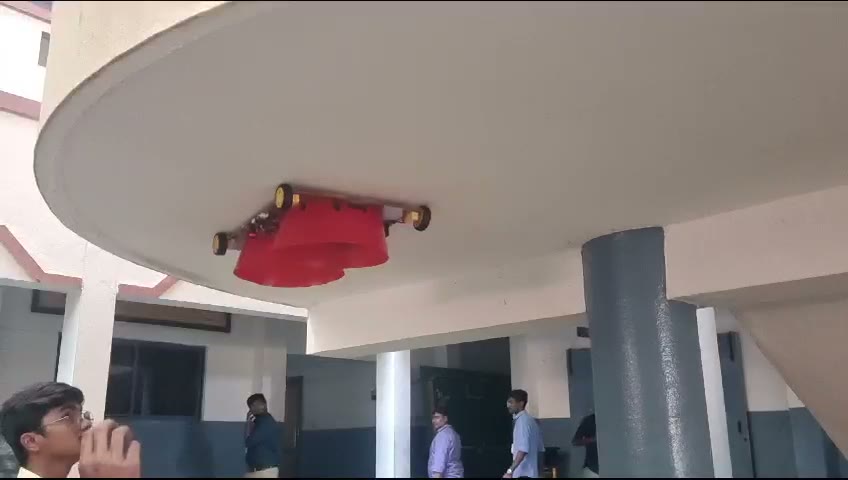 IN-THRUST robot holding onto the underside of an outdoor overhang